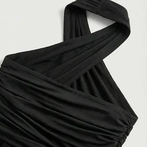 Detalle de un vestido negro con cuello halter y elegante diseño de frente cruzado y fruncido