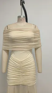 Vista dettagliata dell'abito beige a spalle scoperte con eleganti drappeggi e tulle