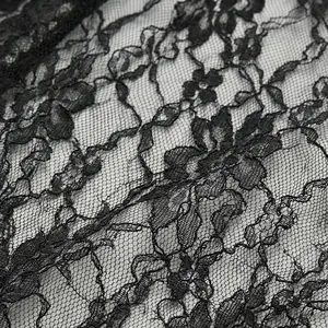 Primer plano del exquisito tejido de encaje floral negro con intrincados patrones