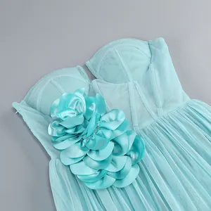 Detail view of aqua mesh dress featuring a large satin flower and corset bodice