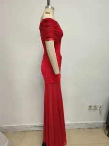 Vista laterale dell'elegante abito lungo rosso a spalle scoperte con inserto in rete su manichino
