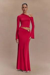 Vista detallada del elegante conjunto rojo de dos piezas con top asimétrico y falda larga