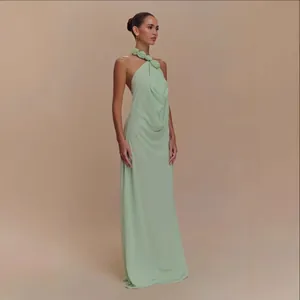 Elegante vestido maxi verde menta con cuello halter, flores 3D y espalda descubierta.