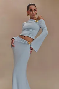 Elegante conjunto de falda larga azul claro con hombros descubiertos y flor dorada