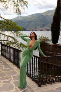 Elegante vestido largo verde de manga larga con escote en V y fruncidos frente al lago.