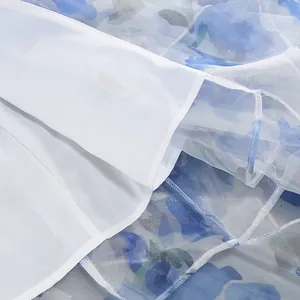 Close-up detail of blue floral chiffon dress showing white inner lining and fine stitching