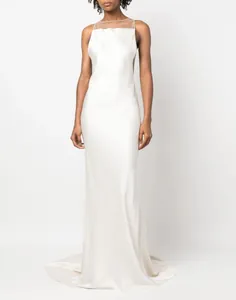 Detailed view of an elegant white backless satin evening gown on a model