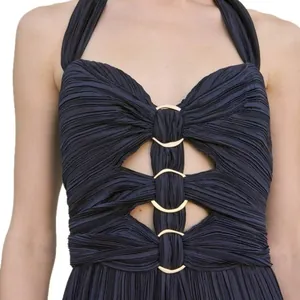 Detail view of navy blue pleated halter dress with elegant gold ring cut-out design.