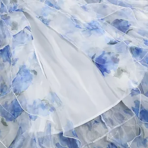 Detailed macro view of blue floral chiffon dress fabric and smooth white inner lining