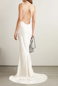 Back view showing elegant white backless evening gown with sheer mesh and straps