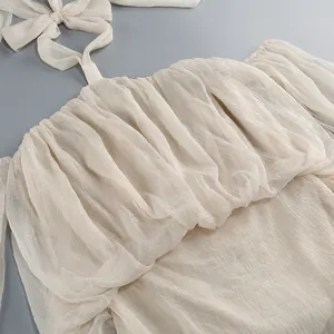 Primo piano di un elegante abito in rete color crema con volant e allacciatura al collo