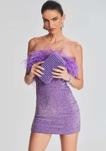 Dettaglio dell'abito di paillettes viola con bordo in piume di struzzo sul décolleté