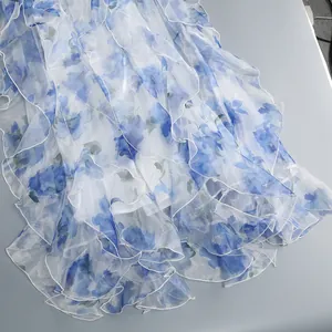 Close-up detail of blue and white floral pattern on layered ruffle summer dress