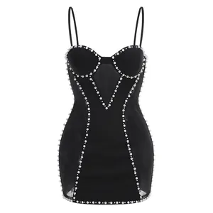 Vista detallada del vestido bandage negro con adornos de perlas y paneles de malla.