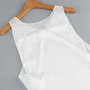 Detailed view of a white evening gown featuring sheer mesh panels and smooth satin fabric