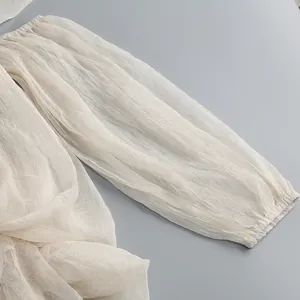 Dettaglio della manica in mesh trasparente con polsino elastico su abito elegante chic.