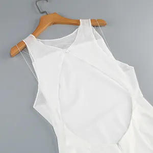 Detail of a white backless evening dress with mesh panels and large oval cutout.
