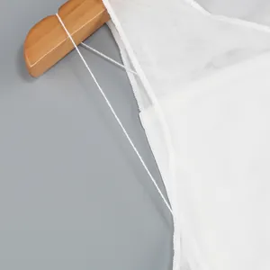 Detailed macro view showing the fine white mesh texture and thin strap of backless gown