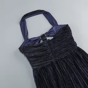 Detail of a deep blue pleated halter neck evening dress with metal ring decoration.