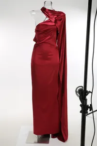 Vista detallada de la textura brillante y el chal drapeado de este vestido de satén burdeos