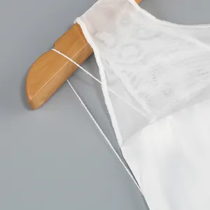 Close-up of white mesh fabric and shoulder strap detail on a slim evening gown