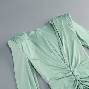Detalle que muestra la elegante textura fruncida y el escote en V de este vestido