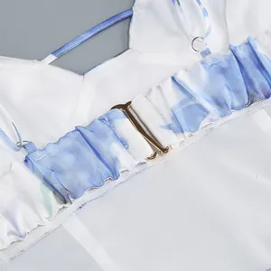 Detail of the gold metal buckle and pleated strap on a blue floral French dress