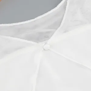 Close-up of white sheer mesh fabric and button closure detail of dress