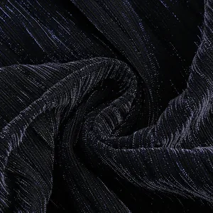 Close-up macro view of deep sea blue pleated fabric with metallic luster for evening dress