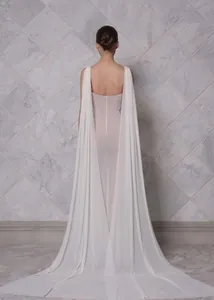 Elegante vestido de noche blanco sin espalda con capa fluida y detalle de cola larga