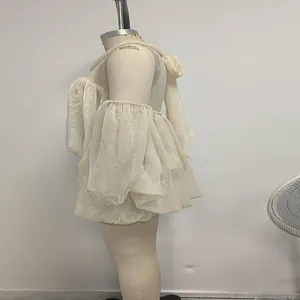 Vista laterale di un abito in tulle stile francese crema esposto su un manichino