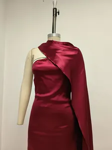 Vista detallada de un elegante vestido de satén burdeos con diseño de chal asimétrico