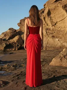Elegante vestido de noche rojo de terciopelo y gasa con detalle de espalda en la playa