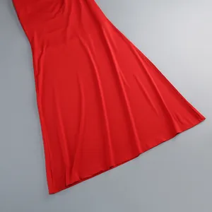 Primer plano del dobladillo del vestido largo rojo con textura de tela drapeada