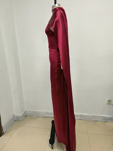 Vista lateral de un vestido de satén burdeos sin espalda con un elegante diseño de capa.