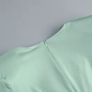 Primer plano de la cremallera trasera oculta en un elegante vestido largo verde menta.