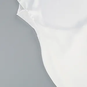 Close-up detail of the smooth white fabric and fine stitching on a backless evening dress.
