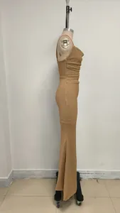 Profil d'une robe longue plissée en maille dorée sur un mannequin de couture.