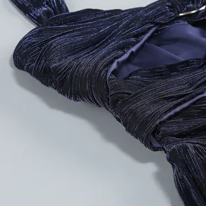 Close-up of deep blue pleated fabric with metallic sheen and silver ring detail.