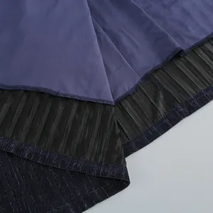 Detailed close-up of deep sea blue pleated evening dress fabric with metallic texture.