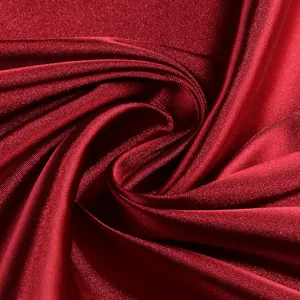 Primer plano de tela de satén rojo intenso con textura de seda de lujo y brillo suave