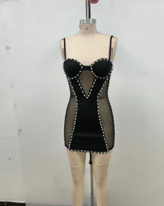 Vista frontal de vestido bandage negro con perlas y malla en un maniquí.
