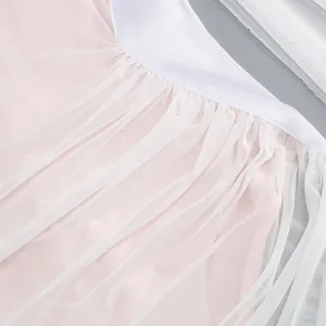 Primer plano del detalle de tela de tul blanco en un vestido de noche rosa claro