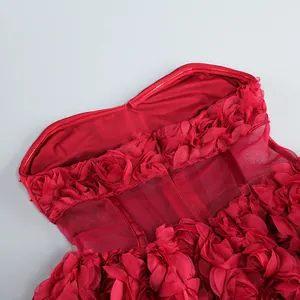 Primer plano de vestido de cóctel rojo con aplicaciones de flores 3D y detalles de malla.