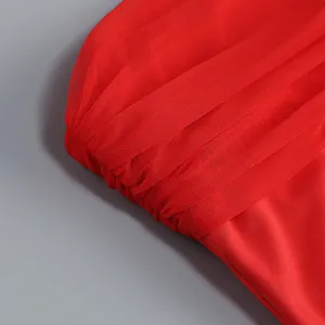 Detalle de los fruncidos de malla roja y la textura plisada de un vestido de palabra de honor
