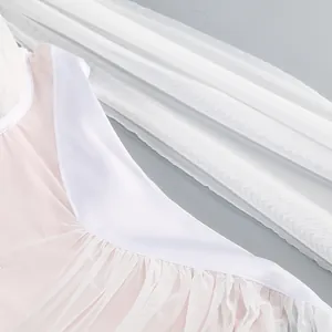 Primer plano de la suave tela de malla rosa y el ribete de satén blanco del vestido.