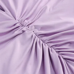 Primer plano del elegante detalle de tela fruncida púrpura en un vestido de gala