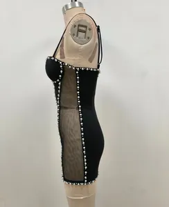 Vista lateral detallada de un vestido ajustado negro con ribete de perlas e inserciones de malla