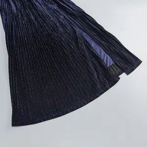 Detailed close-up of a deep blue pleated evening dress featuring elegant high slit design.