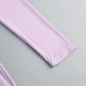 Vista macro detallada del puño con doble costura de un vestido lila de manga larga